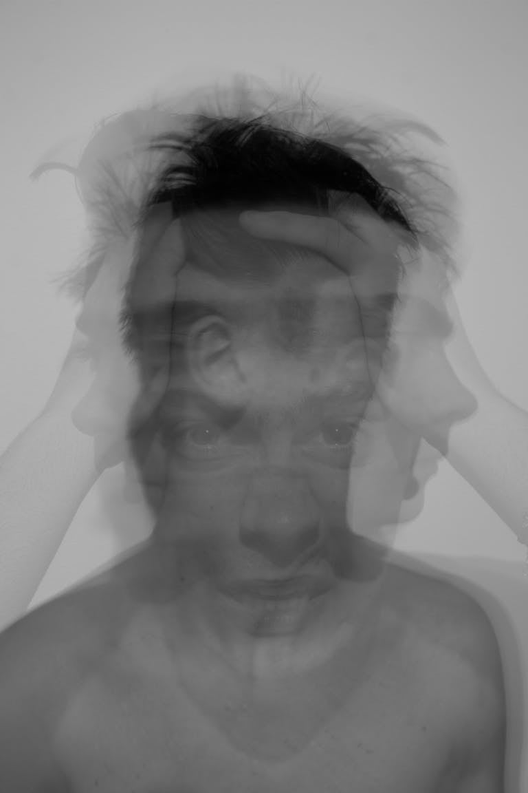 Black and white portrait showing a distorted face expression, evoking confusion.
